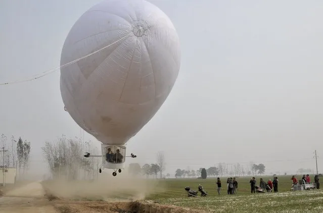 A home-made airship, made by 29-year-old local man Shi Songbo, lifts off during a test flight next to crop fields in Ningling county of Shangqiu, Henan province, China, October 23, 2015. The 10-metre-long, 23-metre-high, two-seated air ship, which cost Shi 300,000 yuan ($47,187 USD) and four months time to make, performed eight successful trial flights on Friday, local media reported. (Photo by Reuters/China Daily)