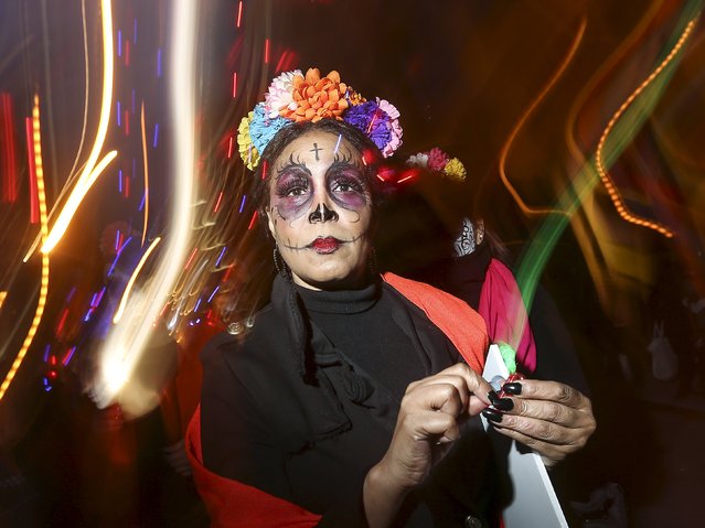 A reveler dressed in a "Dia de Muertos" or "Day of the Dead" theme poses for a photo while taking part in the Greenwich Village Halloween Parade in the Manhattan borough of New York, October 31, 2015. (Photo by Carlo Allegri/Reuters)