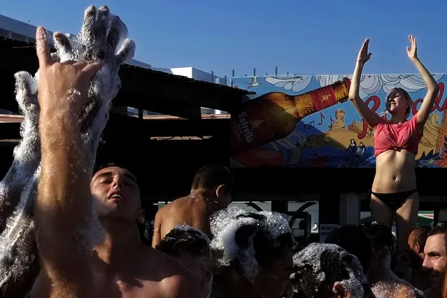 In this photo taken on Sunday July 23, 2017, Tourists dance in the foam at a beach bar in “Nissi beach” in southeast resort of Ayia Napa, Cyprus The mayor of Ayia Napa Yiannis Karousos, the seaside town that has long been a favorite for hundreds of thousands of holidaymakers annually, wants to keep out boorish, ill-mannered louts that he says on Wednesday, March 14, 2018, give his town a bad name and infuriate locals and other tourists alike. (Photo by Petros Karadjias/AP Photo)