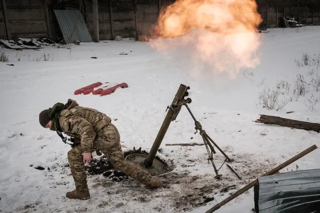 A Ukrainian serviceman of the State Border Guard Service fires a mortar toward the Russian position in Bakhmut on February 16, 2023, as the head of Russia's mercenary outfit Wagner said it could take months to capture the embattled Ukraine city and slammed Moscow's “monstrous bureaucracy” for slowing military gains. Russia has been trying to encircle the battered industrial city and wrest it ahead of February 24, the first anniversary of what it terms its “special military operation” in Ukraine. (Photo by Yasuyoshi Chiba/AFP Photo)