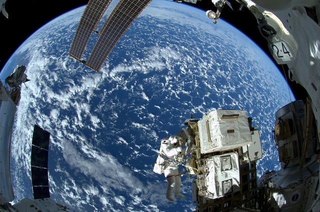 NASA astronaut Reid Wiseman and European Space Agency astronaut Alexander Gerst (not shown) works outside the space station's Quest airlock in the first of three spacewalks for the Expedition 41 crew aboard the International Space Station in this NASA image released October 8, 2014. (Photo by Reuters/NASA)