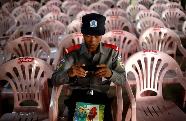 Myanmar’s specially recruited police officer for election duties checks his mobile phone during a break of training in Mandalay, Myanmar, Wednesday, October 21, 2015. Myanmar temporally recruited 40,000 new officers for the upcoming election duties schedule for November 8. (Photo by Hkun Lat/AP Photo)