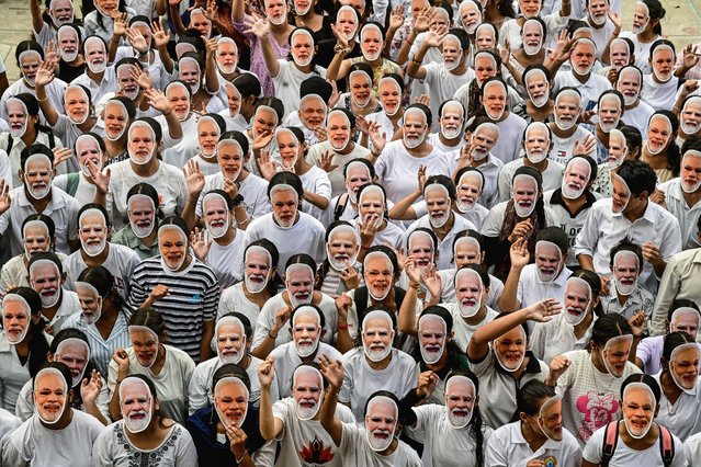 Students wear masks of India's Prime Minister Narendra Modi to celebrate his 75th birthday, in Chandigarh on September 17, 2025. (Photo by AFP Photo/Stringer)