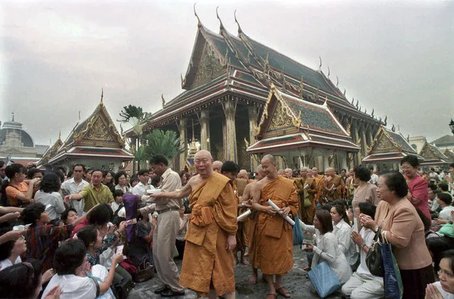 In this September 20, 1997, file photo, Buddhist monks bless thousands of followers during a ceremony at the Emerald Buddha Temple in Bangkok, Thailand, to boost public morale during the massive economic crisis in the nation. Asian governments and economies have recovered from the financial meltdown that spread through much of Asia 20 years ago, but many in people Thailand, the epicenter of the crisis, recall painful memories of living through it and lost everything. (Photo by Thaksina Khaikaew/AP Photo)