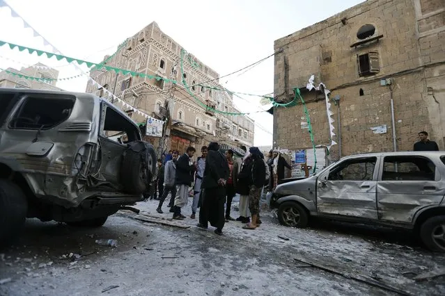 People gather at the site of a bomb explosion in Sanaa December 23, 2014. (Photo by Khaled Abdullah/Reuters)