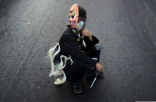 A boy with a mask and a painted face sits on a street as he takes part in an annual carnival called “Alegria por la Vida” (Joy for life) in Managua April 27, 2013. (Photo by Oswaldo Rivas/Reuters)