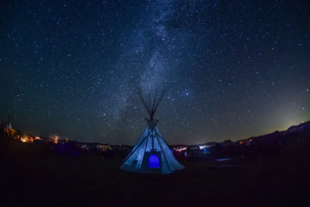 As night falls, the Milky Way begins to form directly behind a teepee at Oceti Sakowin prayer camp, Standing Rock, USA on February 21, 2018. (Photo by Ryan Vizzions/The Guardian)