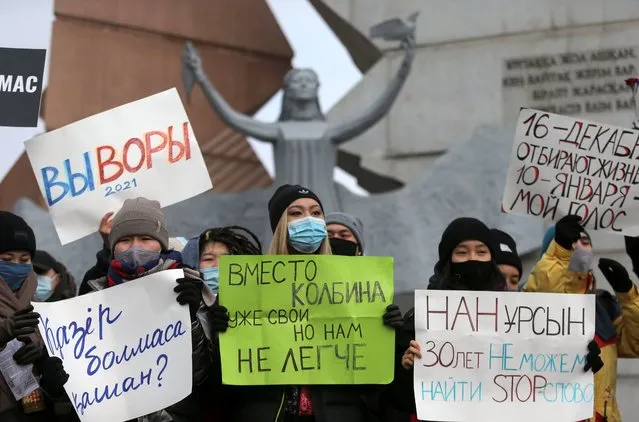 Protesters hold placards during an opposition rally marking Independence Day in Almaty, Kazakhstan December 16, 2020. Upper placards refer to the upcoming parliamentary election and read: “You are thieves. 2021” and “Life is taken away on December 16, my vote on January 10”. (Photo by Pavel Mikheyev/Reuters)
