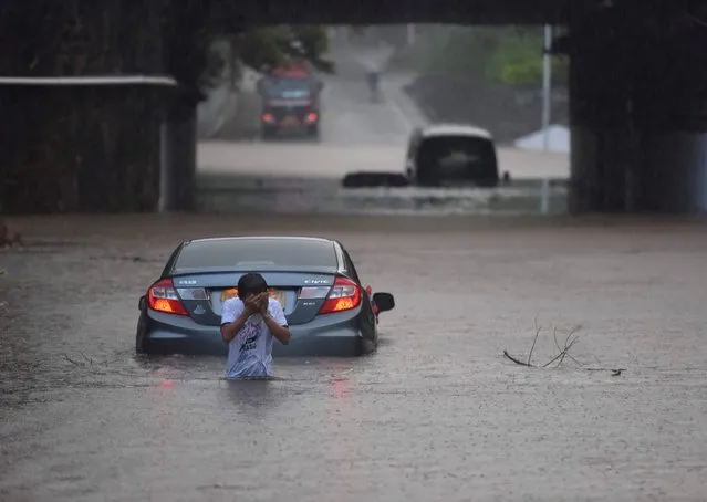 A man wades through a flooded street as he leaves a stranded car, in Qionghai, Hainan province, China, November 22, 2015. (Photo by Reuters/Stringer)