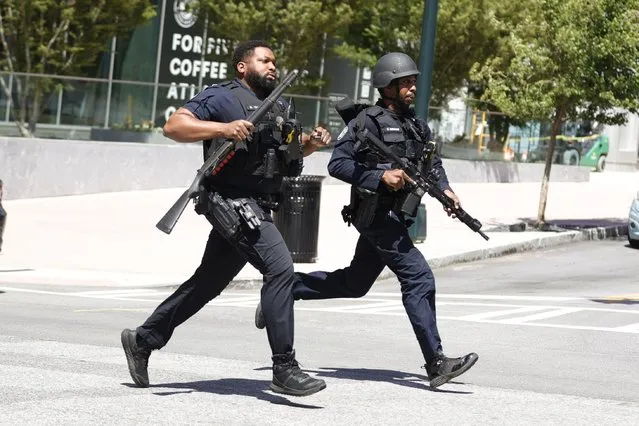 Law enforcement officers run near the scene of an active shooter on Wednesday, May 3, 2023 in Atlanta. (Photo by Alex Slitz/AP Photo)