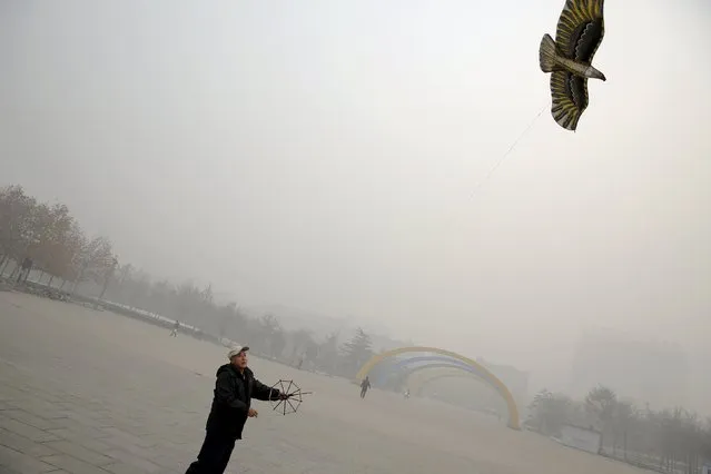 A man plays with a kite on an extremely polluted day in Baoding, China November 30, 2015. Baoding, located in Hebei province neighbouring Beijing was the most polluted city in China in the first half of 2015, according to the country's Ministry of Environmental Protection. (Photo by Damir Sagolj/Reuters)