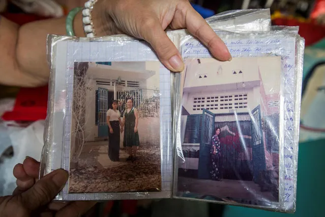 Nguyen Thi Tanh, 75, shows old family photos in her 6.7- square- meter home in Ho Chi Minh City on April 24, 2018. (Photo by Thanh Nguyen/AFP Photo)
