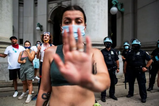 A protester blocks the view while another protester was detained by NYPD after pepper spraying another protester and police near the area known as the “City Hall Autonomous Zone” that has been established to protest the New York Police Department and in support of “Black Lives Matter” near City Hall in lower Manhattan, in New York City, July 3, 2020. (Photo by Eduardo Munoz/Reuters)