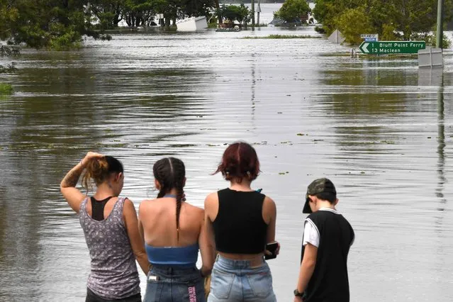 Residents stand by a flooded street in Lawrence suburb, some 70 kilometres New South Wales border city Lismore, on March 1, 2022. (Photo by Saeed Khan/AFP Photo)
