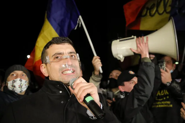 George Simion, one of the leaders of the Alliance for the Unity of Romanians or AUR, speaks to protesters after a deadly fire at a hospital treating COVID-19 patients in Bucharest, Romania, Saturday, January 30, 2021. Hundreds marched during a protest organized by the AUR alliance demanding the resignation of several top officials, after a fire early Friday at a key hospital in Bucharest that also treats COVID-19 patients killed five people. (Photo by Vadim Ghirda/AP Photo)
