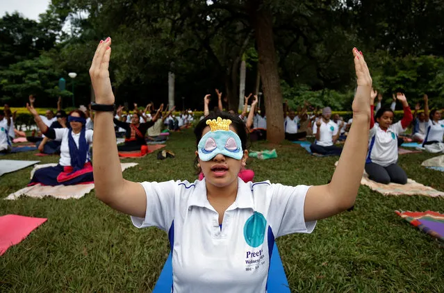 A girl wears a blindfold as she attends a yoga session at a park ahead of International Yoga Day, in Bengaluru, June 20, 2018. (Photo by Abhishek N. Chinnappa/Reuters)