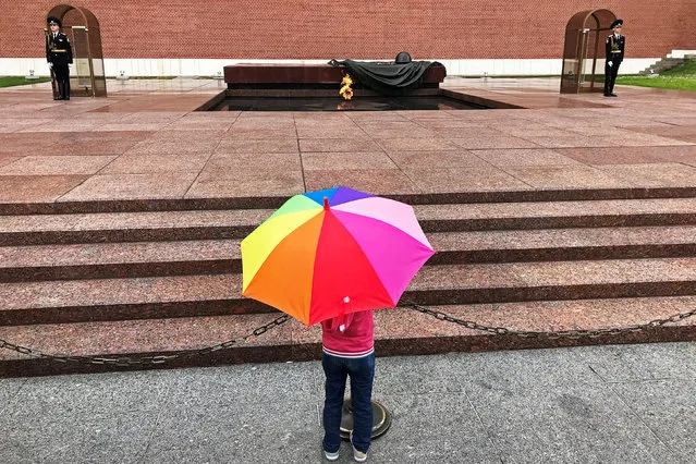 A girl stands in front of the Eternal Flame at the Kremlin in Moscow, Russia July 5, 2018. (Photo by Jorge Silva/Reuters)