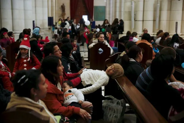 Children wait for the start of a distribution of free toys for low-income families and a picture on the lap of one of the Three Wise Men at Almudena Cathedral in Madrid, Spain, December 22, 2015. (Photo by Susana Vera/Reuters)