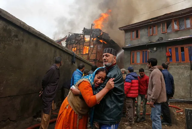 A woman is consoled by her relative as she mourns after seeing her house getting burned during a fire that broke out in one of the houses and got spread in more adjoining houses, in a residential locality in Srinagar, November 21, 2016. (Photo by Danish Ismail/Reuters)