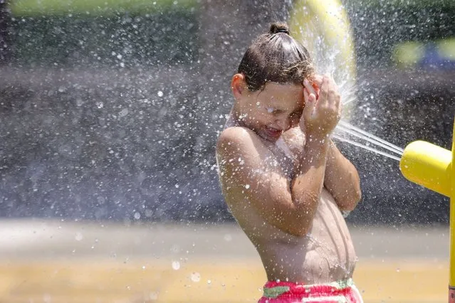 Jaden Mathews, 7, cools down at the Lacy Park splash pad, Tuesday, July 18, 2023 in Tulsa, Okla. (Photo by Mike Simons/Tulsa World via AP Photo)
