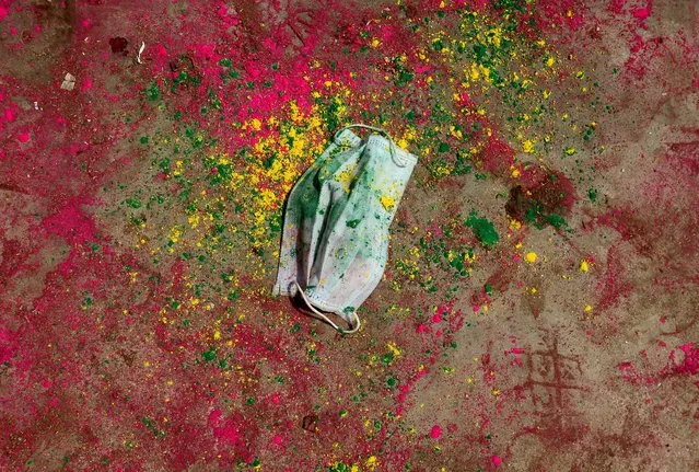 A face mask lies on a road covered with colour powder during Holi celebrations, amidst the spread of the coronavirus disease (COVID-19), in Chennai, India, March 29, 2021. (Photo by P. Ravikumar/Reuters)