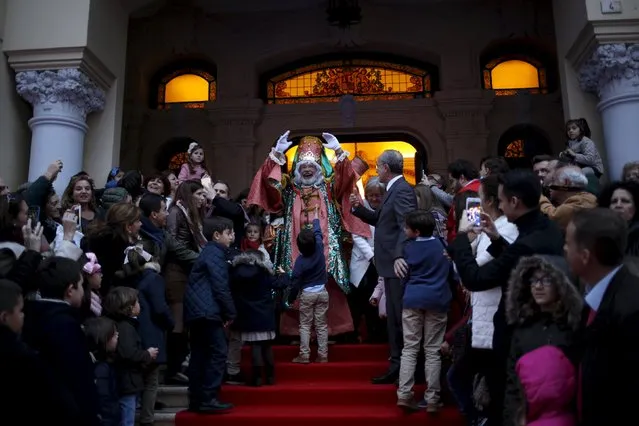 An actor dressed as Melchior, one of the Three Wise Men, greets people outside the town hall before the traditional Epiphany parade in Malaga, southern Spain, January 5, 2016. (Photo by Jon Nazca/Reuters)