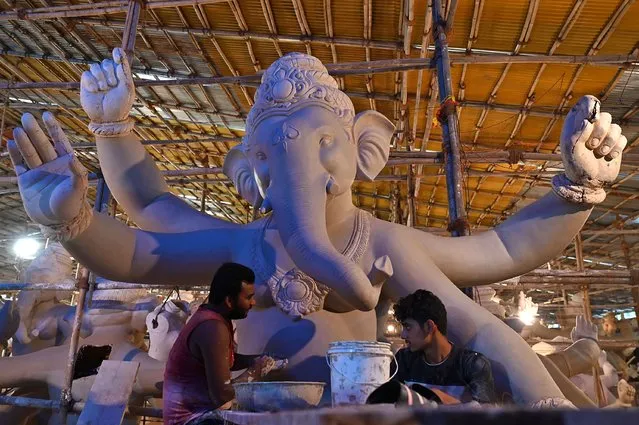 Artisans work on an idol of the elephant-headed Hindu god Ganesha at a workshop ahead of the Ganesh Chaturthi festival in Mumbai on August 7, 2023. (Photo by Punit Paranjpe/AFP Photo)