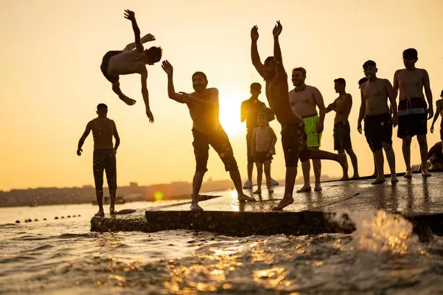 A man is thrown by friends into the sea for fun at the beach at Menekse, in Istanbul on July 23, 2023. Turkey is bracing for an expected heat wave over the next week with meteorological forecasts indicating temperatures across the country could increase between 5 and 10 degrees celsius above the normal seasonal temperatures. (Photo by Yasin Akgul/AFP Photo)