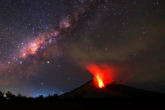 Hot lava flows down the Mount Sinabung volcano in the night in Karo, North Sumatra on July 30, 2017. Sinabung roared back to life in 2010 for the first time in 400 years. After another period of inactivity it erupted once more in 2013, and has remained highly active since. (Photo by Tibta Pangin/AFP Photo)