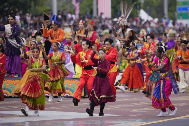 Dancers perform during the National Day parade in Putrajaya, Malaysia, Thursday, August 31, 2023. Prime Minister Anwar Ibrahim urged Malaysians to unite and reject racial and religious bigotry, as the country marked its 66th year of freedom from British rule on Thursday with fireworks and a street parade. (Photo by Vincent Thian/AP Photo)