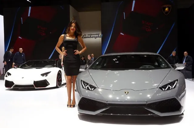 A model poses between a Lamborghini Aventador LP 700-4 and a Lamborghini Huracan LP 610-4 (R) during the second press day ahead of the 85th International Motor Show in Geneva March 4, 2015.  REUTERS/Arnd Wiegmann   