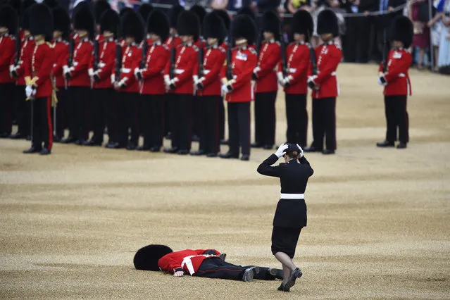 A Guardsman faints at Horseguards Parade for the annual Trooping the Colour ceremony in central London, Britain June 11, 2016. Trooping the Colour is a ceremony to honour Queen Elizabeth's official birthday. The Queen celebrates her 90th birthday this year. (Photo by Dylan Martinez/Reuters)