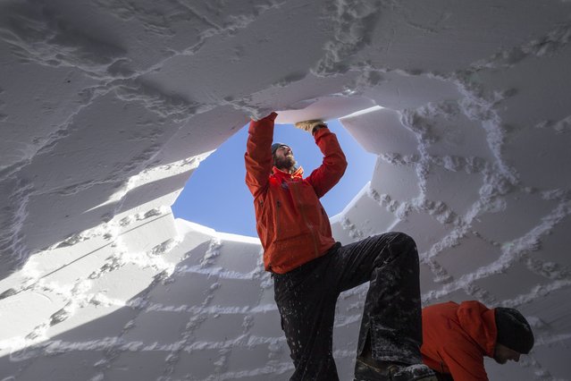 Reto Gilli (L), manager of the Igloo-village in Zermatt, is piling one of the last snow bricks during the builing work for the world record attempt for the largest classic igloo with a diameter of 13 meters and a ceiling hight of 11 meters in Zermatt, Switzerland, 21 January 2016. This world record attempt is hold during the 20th anniversary of the Igloo-village on an altitude of 2,727 meters. A total of 1,700 snow bricks are needed during the construction phase of two weeks. By now, the largest Igloo was built on 19 February 2011 in Grand Falls, Canada with a diameter of 9,2 meters and a ceiling hight of 5,3 meters. (Photo by Dominic Steinmann/EPA)