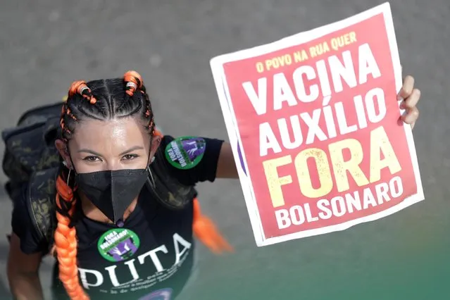 A demonstrator holds a banner reading, “The people on the street want vaccine emergency aid. Bolsonaro out”, during a protest against Brazil's President Jair Bolsonaro in Brasilia, Brazil, May 29, 2021. (Photo by Ueslei Marcelino/Reuters)