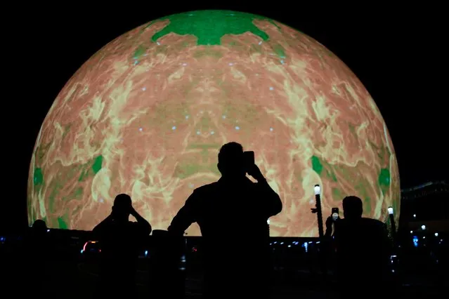 People take pictures during the opening night of the Sphere, Friday, September 29, 2023, in Las Vegas. (Photo by John Locher/AP Photo)