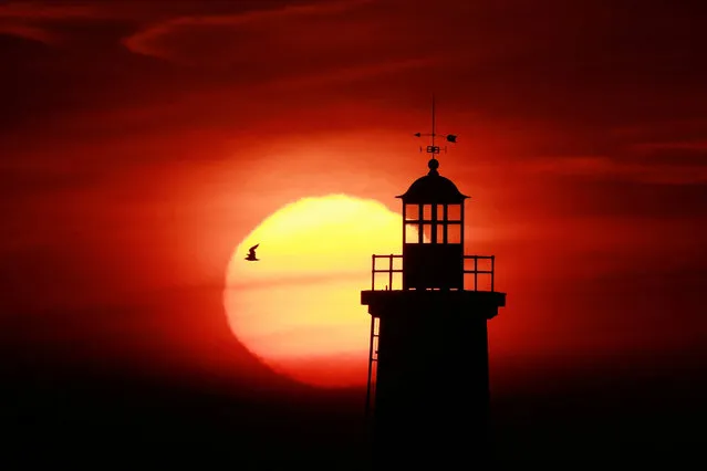 The sun rises behind “La Perdrix” lighthouse in Loctudy, Brittany, France on September 3, 2023. (Photo by Pascal Rossignol/Reuters)