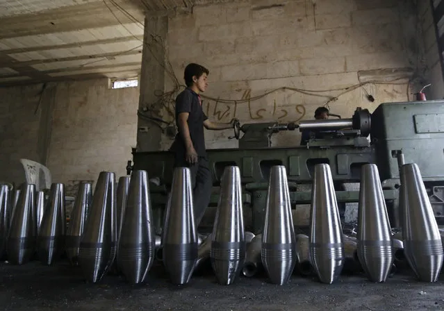 Rebel fighters make improvised mortar shells inside a weapons factory in the southern countryside of Idlib September 9, 2014. (Photo by Khalil Ashawi/Reuters)