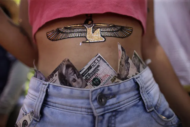 A reveller is seen with dollar bills tucked behind waistband of jeans during an annual block party known as “Enquanto isso na Sala da Justiça” (Meanwhile, in the justice room), one of the many carnival parties taking place in the neighbourhood of Olinda, Brazil February 7, 2016. (Photo by Ueslei Marcelino/Reuters)