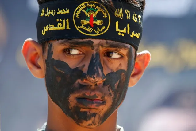 A young Palestinian wearing Al-Quds Brigades headband looks on during a graduation ceremony at a military summer camp organised by the Islamic Jihad Movement, in Gaza City on June 30, 2021. (Photo by Suhaib Salem/Reuters)