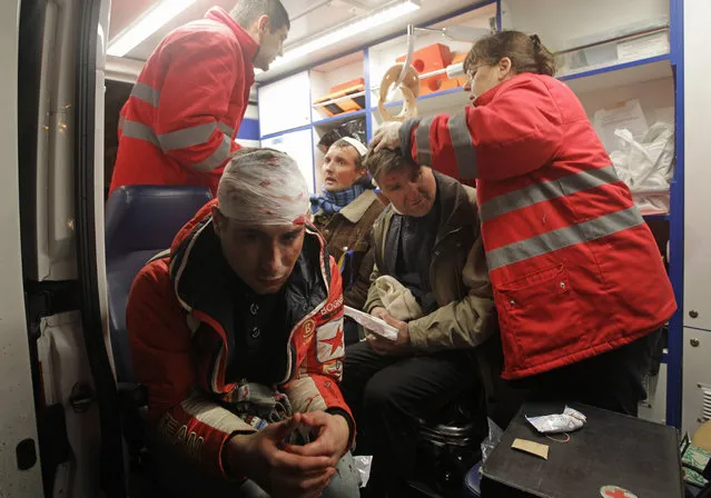Injured protesters receive medical help in ambulance after Ukrainian riot police broke up a rally demanding the resignation of President Viktor Yanukovych, at the Independence Square in downtown Kiev, Ukraine, on Saturday, November 30, 2013. (Photo by Sergei Chuzavkov/AP Photo)