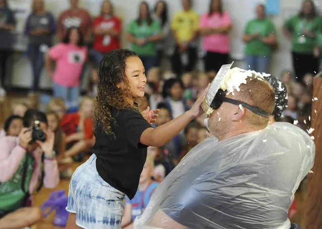 Third-grader Kate Ikeard hits Principal Kevin Lowe in the face with a pie  as part of a “Pie a Principal Day” celebration assembly for High Attendance Day at Meadow Lands Elementary School in Owensboro, Ky., on September 16, 2022. (Photo by Alan Warren/The Messenger-Inquirer via AP Photo)
