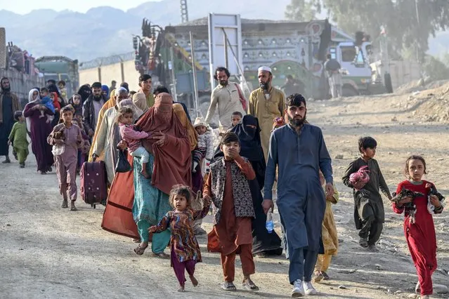 Afghan refugees in Pakistan walk towards the Pakistan-Afghanistan Torkham border on November 3, 2023, following Pakistan's government decision to expel people illegally staying in the country. More than 165,000 Afghans have fled Pakistan since Islamabad issued an ultimatum to 1.7 million people a month ago to leave or face arrest and deportation, officials said on November 2. (Photo by Abdul Majeed/AFP Photo)