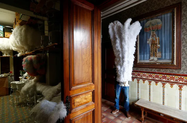 An artisan poses with an ostrich feather adorned hat worn by the “Gilles of Binche” performers during the Binche carnival, a UNESCO World Heritage event, in a shop in Binche, Belgium February 1, 2019. (Photo by Francois Lenoir/Reuters)