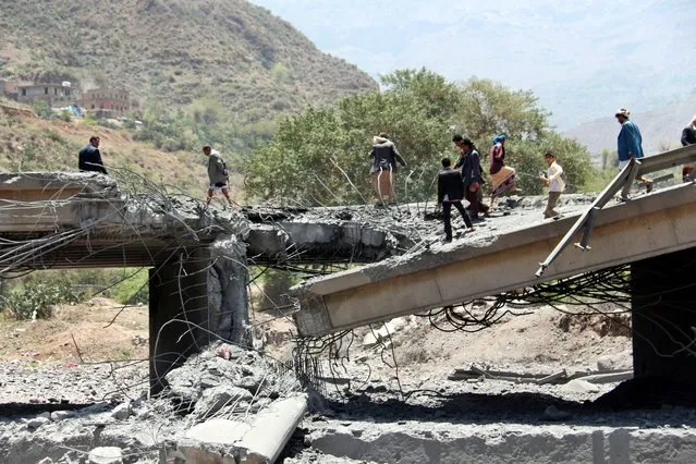 Yemenis stand on a bridge allegedly hit by an airstrike carried out by the Saudi-led coalition near the central city of Ibb, Yemen, 21 April 2015. According to reports, at least 24 people, allegedly all civilians, were killed when an airstrike targeting Houthi militia members hit the bridge, adding to the growing death toll from the past weeks of fighting which some agencies report as reaching 944 with 3487 wounded. (Photo by EPA/Stringer)