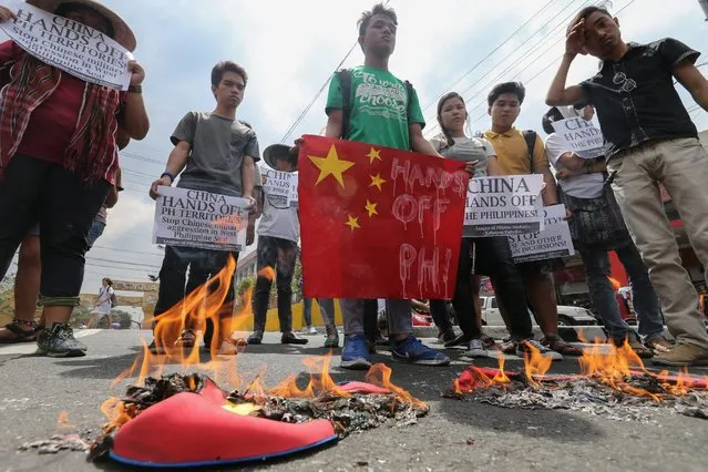 Filipino students burn mocks of Chinese vessels during a protest against China's aggression in the South China Sea in Manila, Philippines, 03 March 2016. According to the student group's statement, they denounced China's aggression and criticized the Philippine government for their lack of action and decisiveness defending the islands. Chinese vessels were spotted near a Philippine atoll prompting Manila to urge China on 02 March to exercise self-restraint in the South China Sea, where Beijing claims several territories administered by neighbouring countries. (Photo by Mark R. Cristino/EPA)