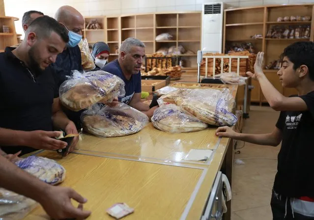 People queue to buy bread from a bakery, after the central bank decided to effectively end subsidies on fuel imports, in Sidon, Lebanon, August 13, 2021. (Photo by Aziz Taher/Reuters)