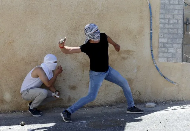 Palestinian youths throw stones towards Israeli police during clashes in the East Jerusalem neighbourhood of A-tur, after a Palestinian youth was killed by Israeli security forces April 25, 2015. (Photo by Ammar Awad/Reuters)