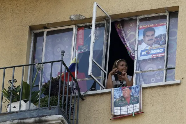 A supporter of Venezuela's President Nicolas Maduro attends a rally from her window to celebrate May Day in Caracas May 1, 2015. (Photo by Jorge Silva/Reuters)