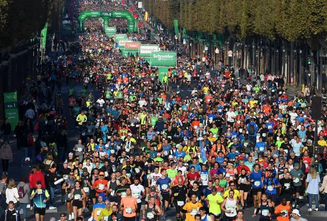 Runners compete on the Champs-Elysees avenue in the 42,195 km Paris Marathon, as part of its 45th edition on October 17, 2021. (Photo by Alain Jocard/AFP Photo)