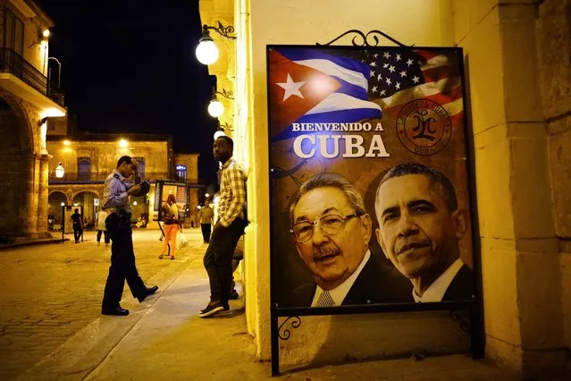 A poster features portraits of Cuba's President Raul Castro, left, and U.S. President Barack Obama and reads in Spanish “Welcome to Cuba” outside a restaurant in Havana, Cuba, Thursday, March 17, 2016. Obama is scheduled to travel to the island on March 20, the first U.S. presidential trip to Havana in nearly 90 years. (Photo by Ramon Espinosa/AP Photo)